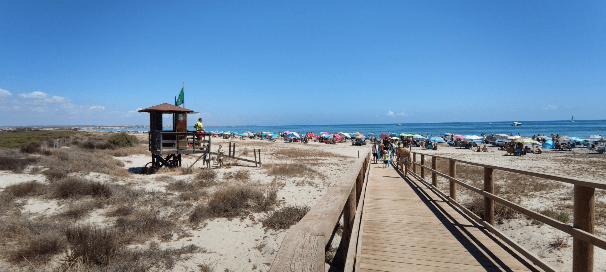 picture from playa de la torre derribada with numerous visitors and a lifeguard