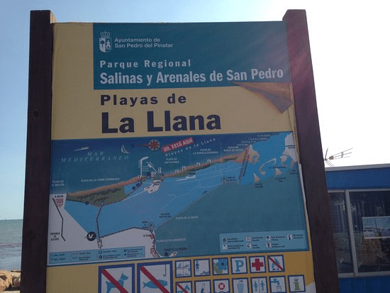 Playa de la Llana sign with a map and rules
