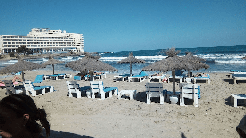 image showing multiple umbrellas and loungers on the shore of the beach