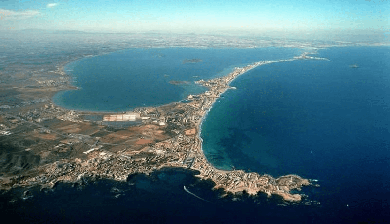 The mar Menort is fed by the Mediterranean, and is on the Mediterranean coastline.