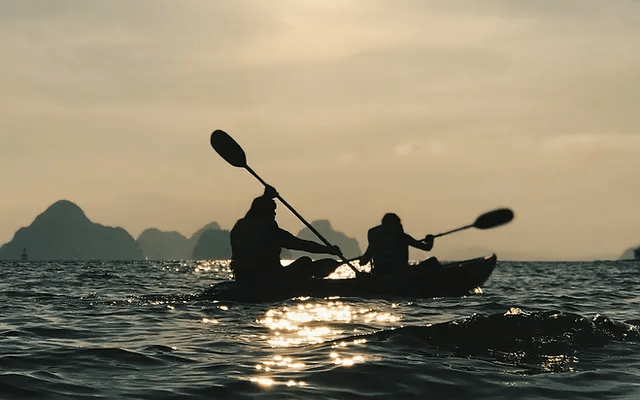 image of two people navigating through the sea with a kayak