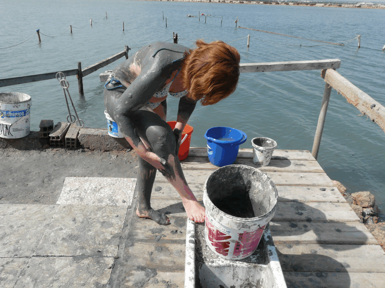picture of a person coating their body with mud